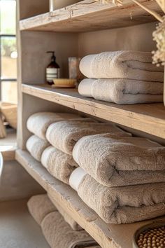 towels are stacked up on shelves in a room with other items and decor around them