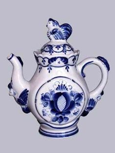 a blue and white porcelain teapot with birds on it's top, sitting in front of a gray background