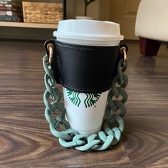 a starbucks cup with chains around it on the floor