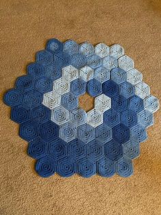 a blue and white crocheted rug with hexagons on the floor