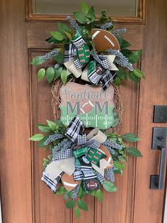 the football mom wreath is hanging on the front door with green and white ribbon around it