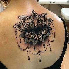 the back of a woman's shoulder with a tattoo design on it