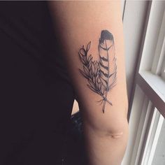 a woman's arm with a tattoo on it and a feather in the middle