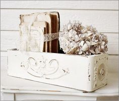 a white box with some books and flowers in it