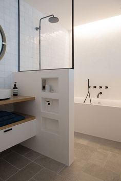 a bathroom with a sink, mirror and bathtub next to a wall mounted shower head