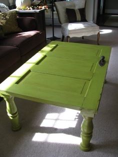 a green table sitting in the middle of a living room