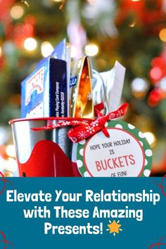 a bucket filled with books sitting in front of a christmas tree