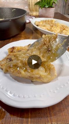 a white plate topped with food on top of a wooden table next to a skillet