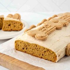 a piece of cake with frosting sitting on top of a white plate next to a wooden spatula