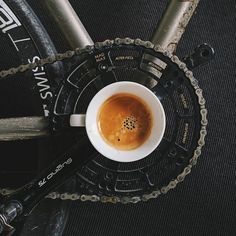 a cup of coffee sitting on top of a bike