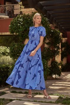 An eye-catching dress deserves to be admired by all! Blue florals overlay this maxi dress with tiers. Short puff sleeves and a round neckline fall in place with an open back. It also has a smocked panel and tie in the back. You can add your heels to go along or some white sandals. - Puffed short sleeves- Pockets- Tiered- Smocked- Color: BlueSize + Fit - Model is 5'11" and wearing size XS- Measurements taken from size S - Chest: 17"- Length: 56 1/2" Fabric Self: 100% Cotton, Lining: 97% Polyester 3% Spandex Style Number STD14320PA Blue Tiered Dress With Smocked Bodice, Blue Maxi Dress With Smocked Bodice And Tiered Skirt, Blue Short Sleeve Maxi Dress With Smocked Back, Blue Floral Print Tiered Dress, Spring A-line Maxi Dress With Smocked Back, Moon Dress, Blue Florals, Blue Maxi, White Sandals