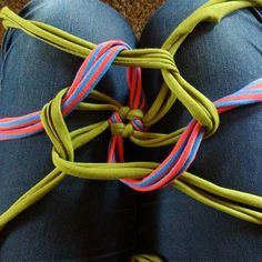 a person wearing blue jeans and green shoes with colorful ties