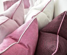 pink and white pillows stacked on top of each other