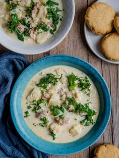 two bowls of soup with biscuits on the side