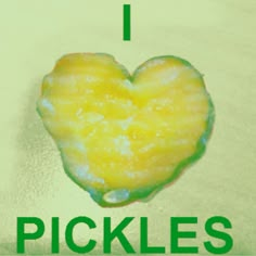 a heart shaped piece of fruit sitting on top of a table next to the words pickles