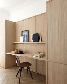 a wooden desk sitting next to a book shelf on top of a hard wood floor