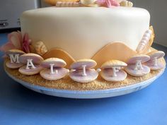 a close up of a cake on a plate with seashells and shells around it