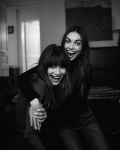 two women are smiling and hugging each other