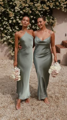 two women standing next to each other in dresses