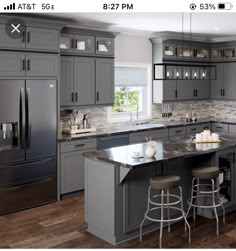 an image of a kitchen setting with gray cabinets and stainless steel appliances in the center