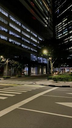 an empty city street at night with buildings in the background