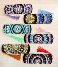 several small purses with tassels on them sitting on top of a wooden table