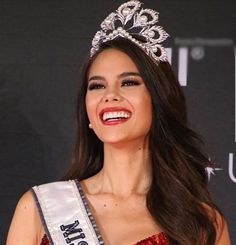 a woman wearing a tiara and smiling at the camera