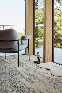 a living room with a chair, lamp and large glass doors leading to an outside deck