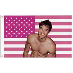 a man with no shirt standing in front of an american flag and smiling at the camera