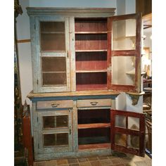 an old wooden cabinet with glass doors and drawers in a room that has tile flooring