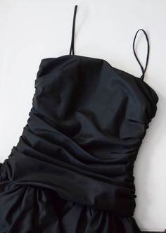 "Description: Black party dress with a drop waist and ruffled skirt. zips up the back and has a large decorative bow. Some tulle under the skirt for fullness. Bodice has boning up the sides. Measurements of garment, allow space for fit. Bust: 32\" some some gathers for cup space. Shown on 36\" and it was way too snug. Waist: 28\" Hips: Open Length: 37\" Skirt length: 15\" I take my measurements flat, and double for circumference. Tag: No brand, just an ILGWU label. Fabric: Polyester Condition: E 80’s Prom Dress Nordstrom, 80 Black Dress, Luxury Black Dress With Gathered Skirt, Luxury Retro Ruffled Dresses, 80s Cocktail Dress Parties, 89s Dresses, Tiffany Valentine Black Dress, 80s Black Dress, Visual Archive