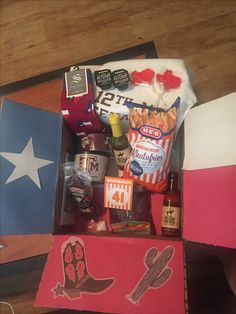 an open box with various items in it on a wooden floor next to a flag