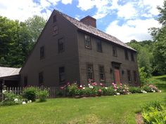 an old house with flowers in the front yard