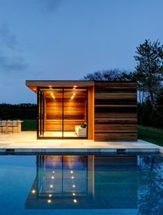 a swimming pool with a small wooden structure next to it and lights on the side