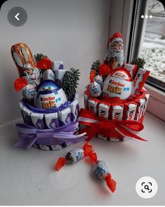 two baskets filled with candy sitting on top of a window sill next to a christmas tree