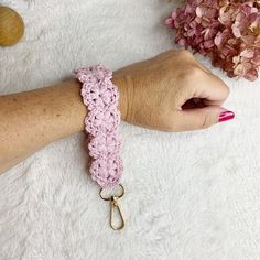 a woman's arm with a pink crochet bracelet on top of it