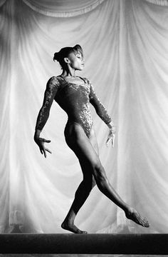 a black and white photo of a woman in a leotard with her legs spread out