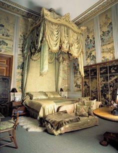 an ornate bedroom with four poster bed and antique furniture in the corner, along with wallpaper on the walls