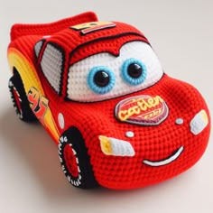 a close up of a toy car on a white surface with blue eyes and mouth