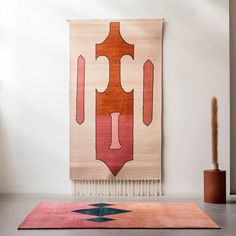 a rug on the floor in front of a white wall with a red and blue design