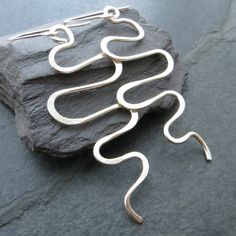 These large sterling silver wave earrings are a real statement piece! They are made from thick silver wire, which I've formed into undulating curves and waves for a bohemian look. I've beaten the tips of the curves to add detail and strength. The earwires are also sterling and are hand forged. Despite their size these earrings are relatively lightweight and have a lovely movement when worn. They'd make a great gift for any fan of contemporary silver jewellery and are sure to get you noticed! Measurements Total length from top of ear wires: 8cm (3 1/8") Wave section length: 6.5cm (2 1/2") Width at widest point: 3cm (1 1/8") Sent nicely gift wrapped in turquoise tissue and an organza pouch, if you prefer a gift box these can be found separately in my shop. Please note this item does not arri Handmade Silver Wavy Jewelry, Contemporary Silver Jewelry, Wave Earrings, Wave Necklace, Bohemian Look, Unusual Design, Lovely Earrings, Earrings Statement, Silver Jewellery