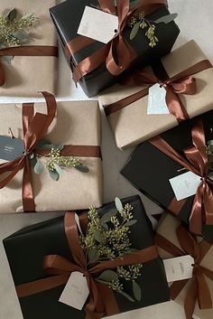 several wrapped presents with ribbons and tags on them