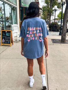 a woman is walking down the sidewalk wearing a t - shirt that says forever has a nice day