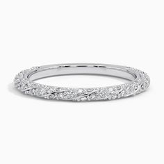 a white gold wedding band with diamonds on the sides and an intricate design in the middle