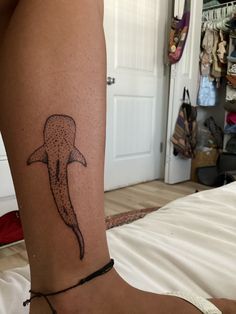 a woman's leg with a tattoo of a dolphin on the side of her body