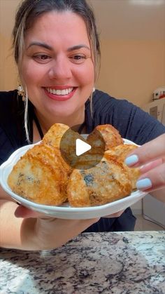 a woman holding a plate with some food on it