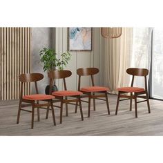 four wooden chairs with orange cushions sit in front of a large window and a potted plant