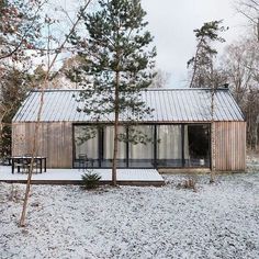 a small wooden cabin in the woods with snow on the ground