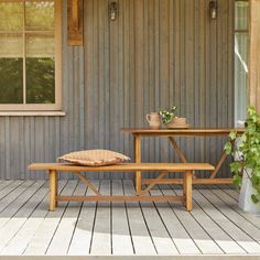 a wooden bench sitting next to a potted plant on top of a wooden table