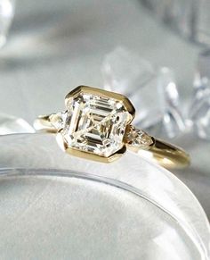 a diamond ring sitting on top of a glass plate